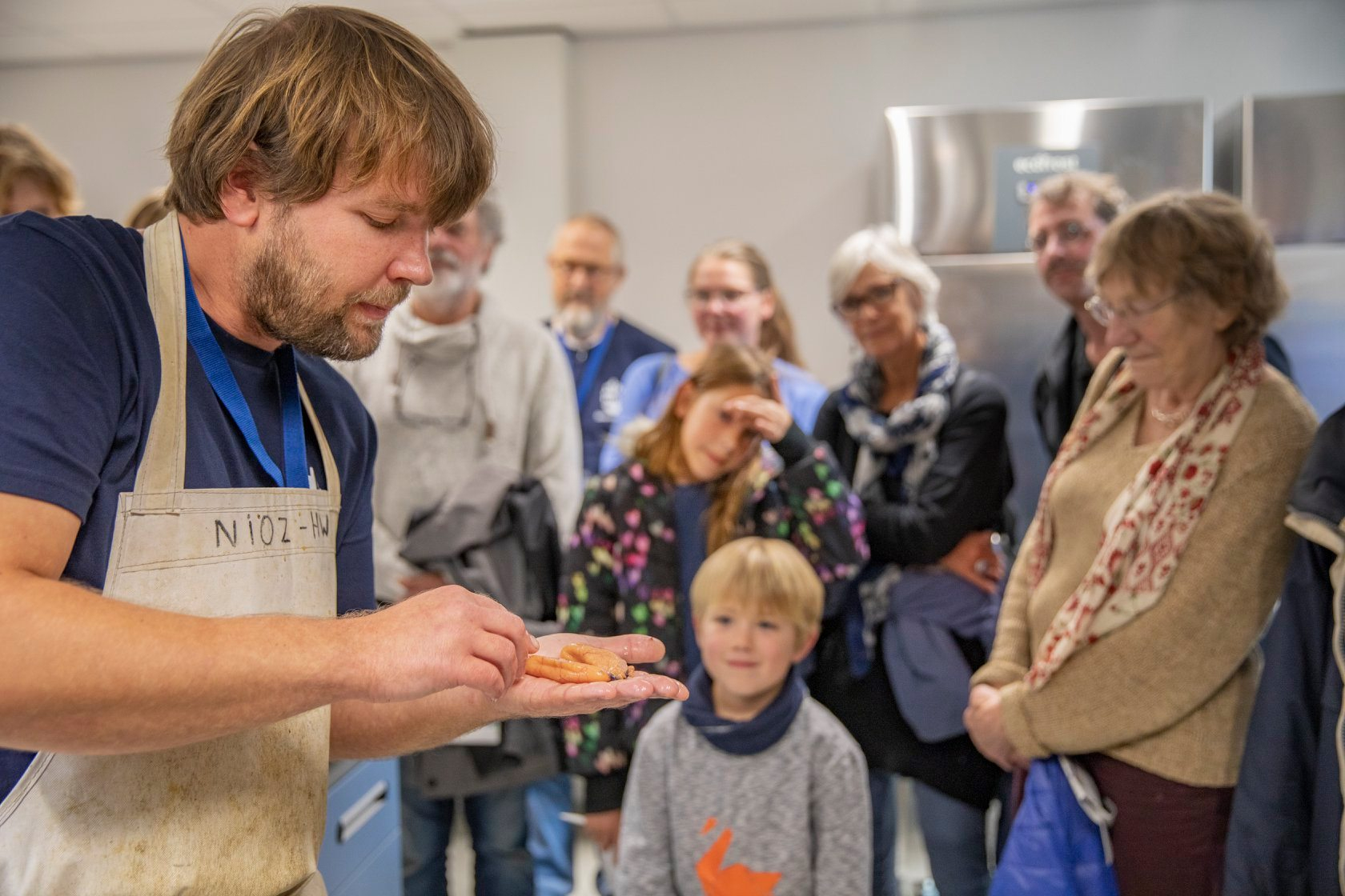 Public fish dissection in the NIOZ dissection lab during an open day, displaying the gonads of a greater forkbeard, with my mentor Hans Witte watching in the background (by Evalien Weterings 2019)